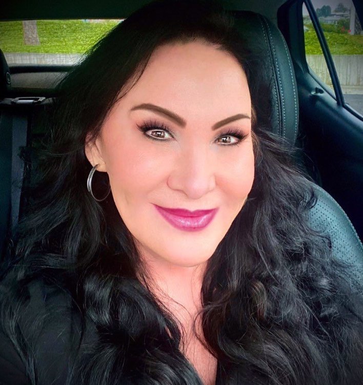 Jana Kind smiling at the camera, wearing black medical scrubs.